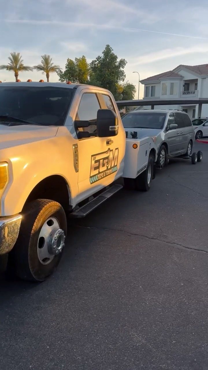 EGM tow truck towing a minivan in a Phoenix neighborhood